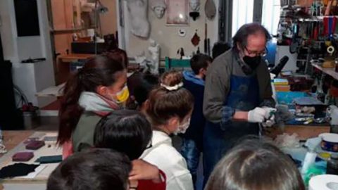 Bimbi che osservano un artigiano al lavoro