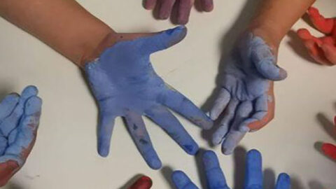 Mani di bambini verniciate di tutti i colori